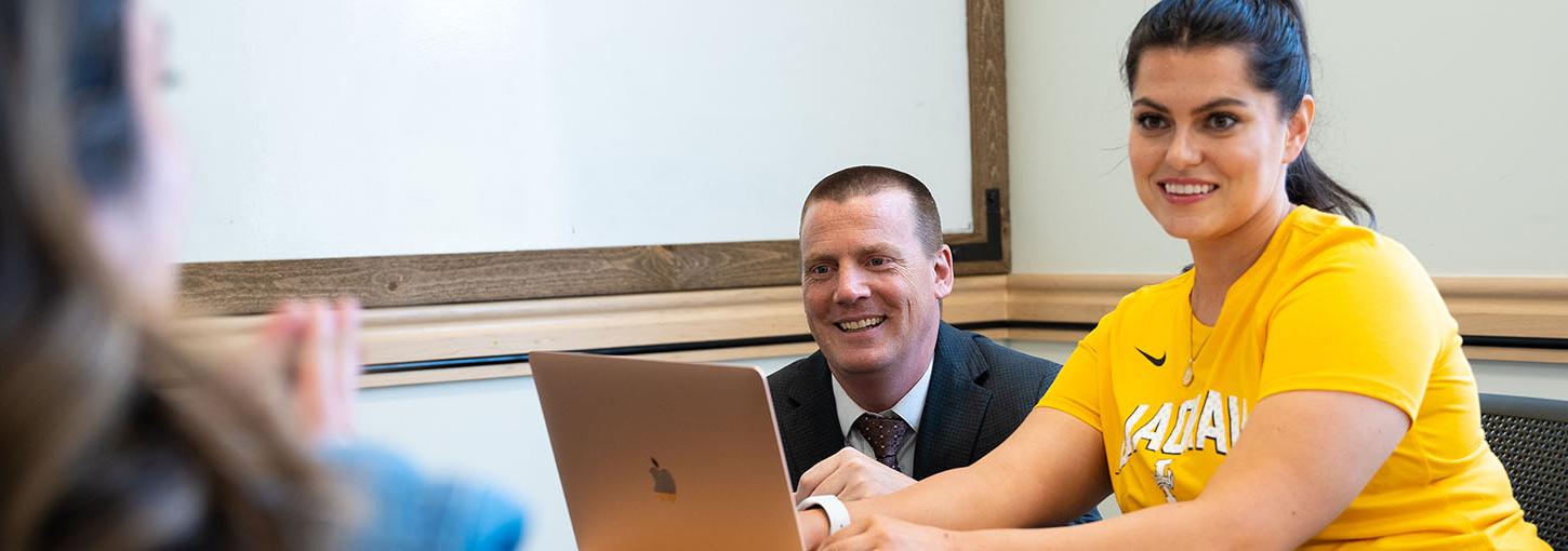 Idaho Law ranked Top Law School for Intellectual Property Law. Image features professor overseeing student working on laptop. 